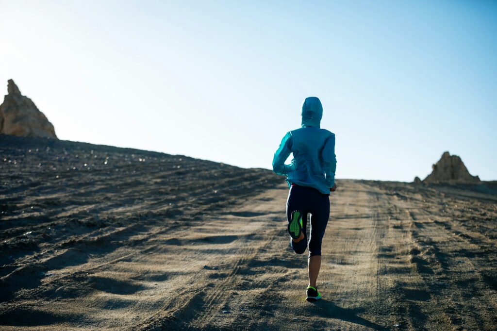 Fitness woman trail runner cross country running on sand desert